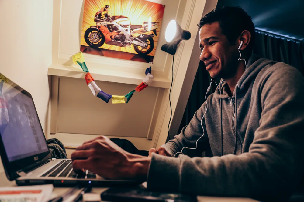 Een huurder met oortjes achter zijn laptop