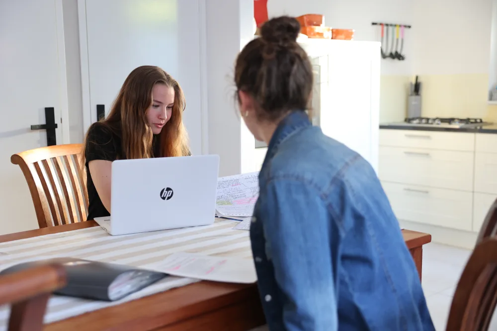 Een huurder bekijkt documenten achter de laptop