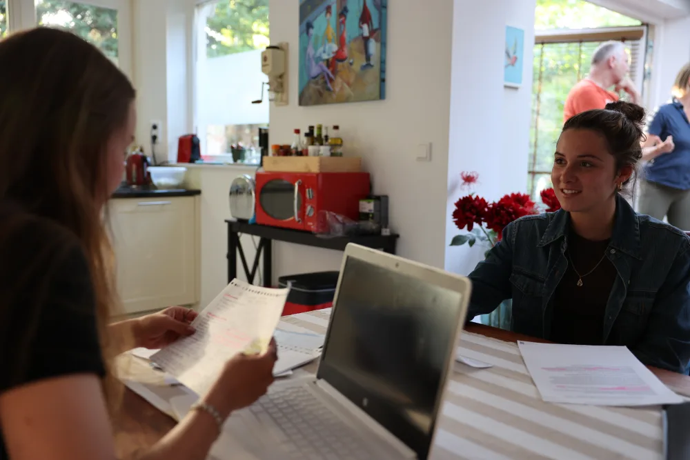 Twee huurders bekijken samen iets op een laptop