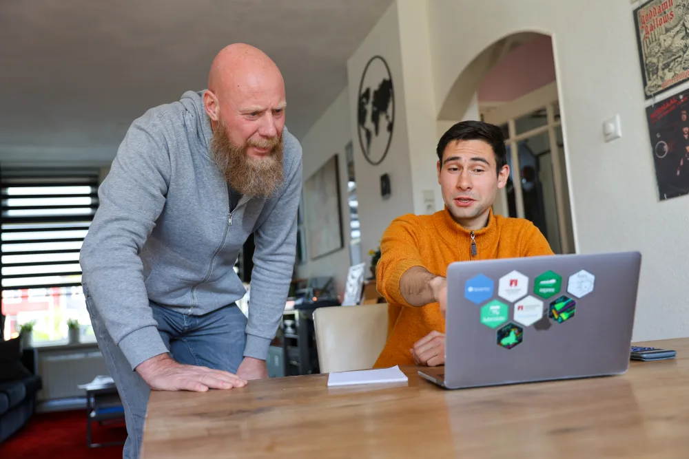 Twee mannen lachen samen op een bankje