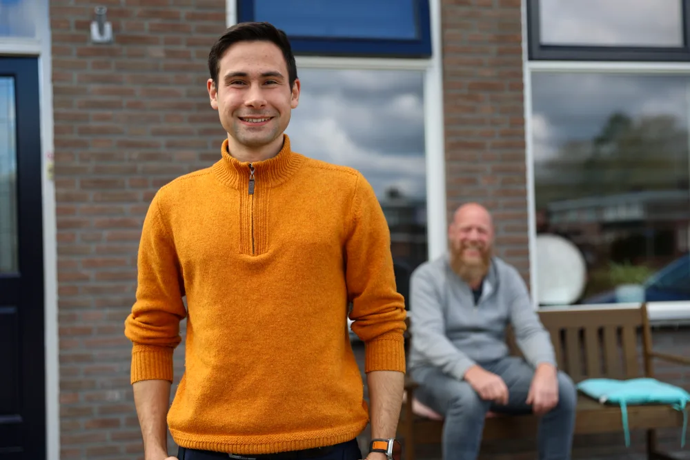 Een huurder voor zijn nieuwe woning, met de host op de achtergrond