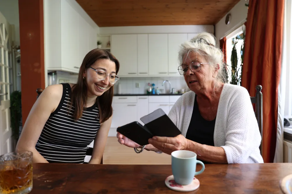 Een host en huurder bekijken samen iets op een telefoon