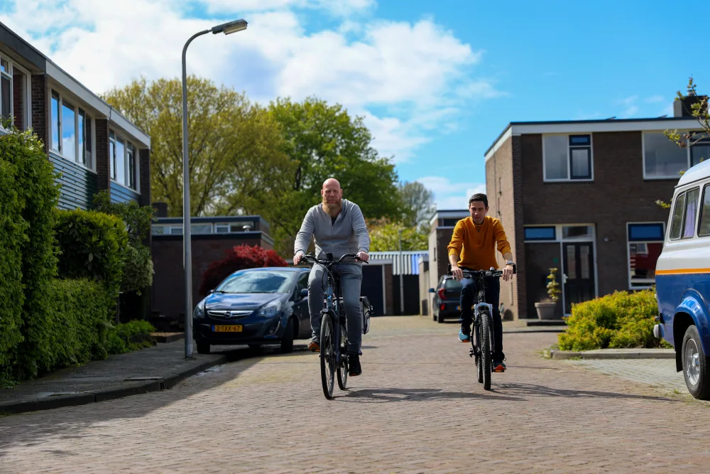 Twee mannen fietsen door de straat