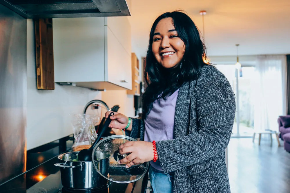 Een huurder kookt in de gedeelde keuken