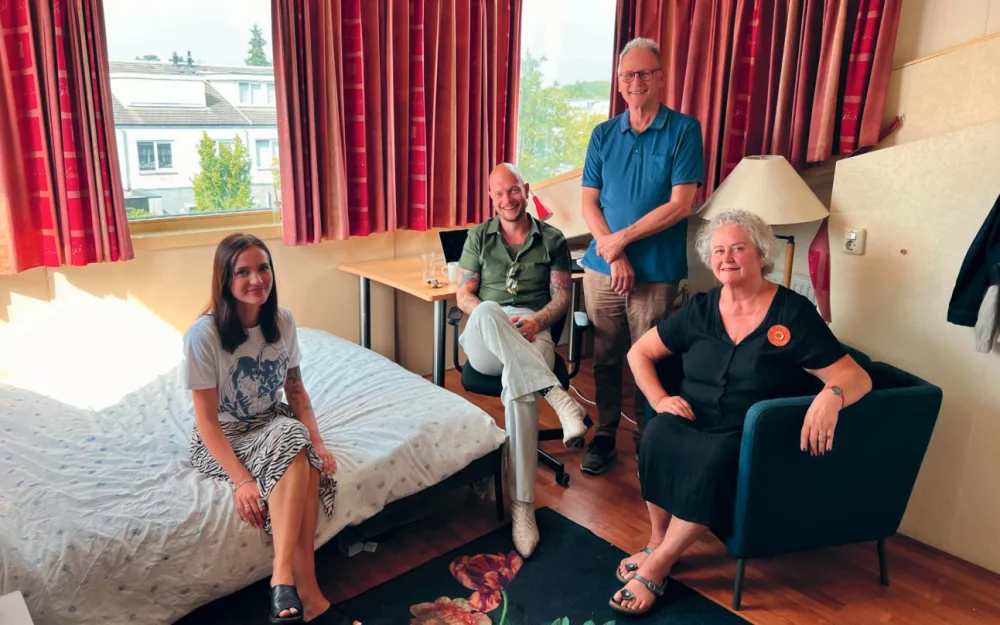 Vier mensen tijdens een bezoek aan een kamer