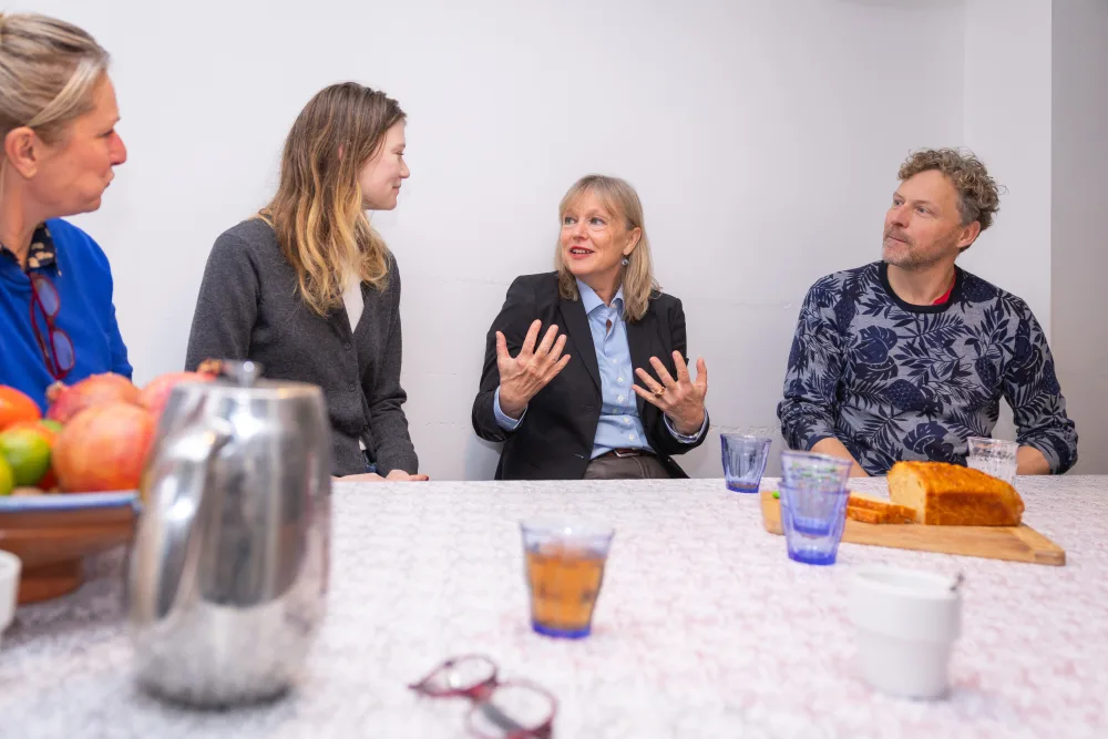 Een groep in gesprek aan de keukentafel