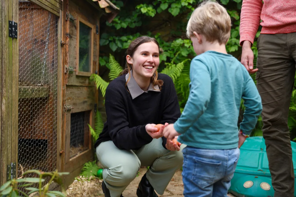 Een huurder lacht met een kind van het gastgezin in de tuin