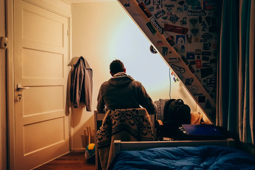 Een student aan het werk in zijn kamer