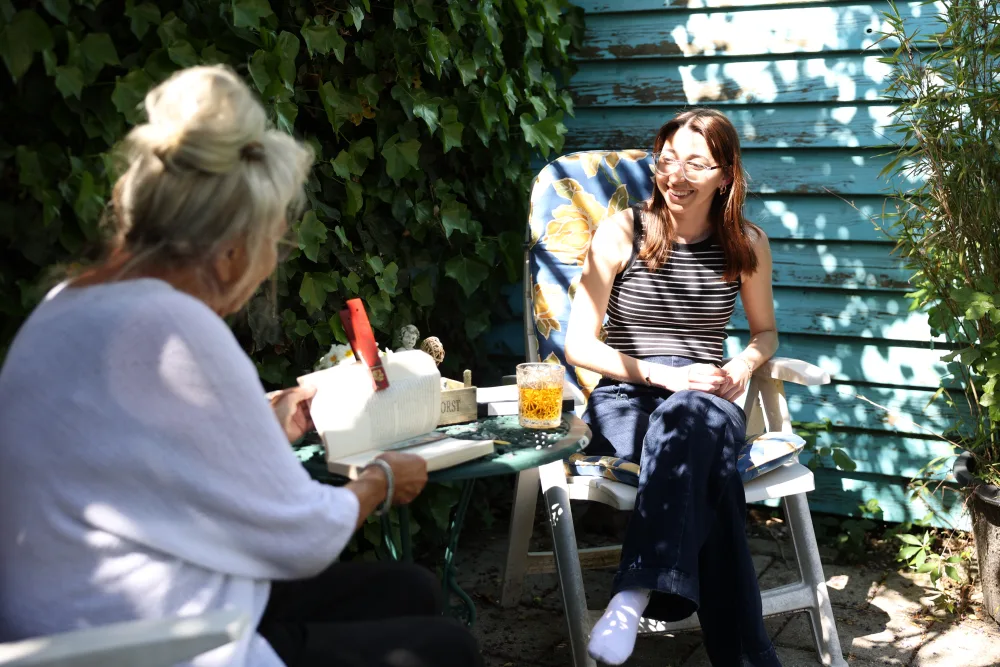 Een host en een huurder in gesprek in de tuin