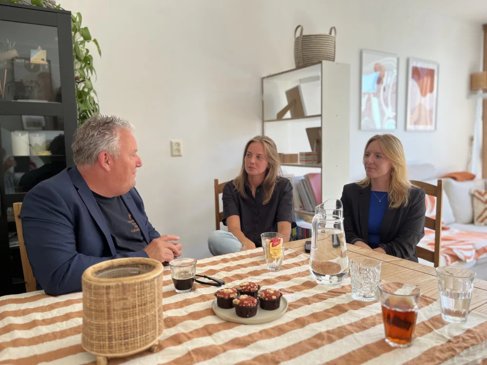 Een gesprek aan tafel tussen een man en twee vrouwen