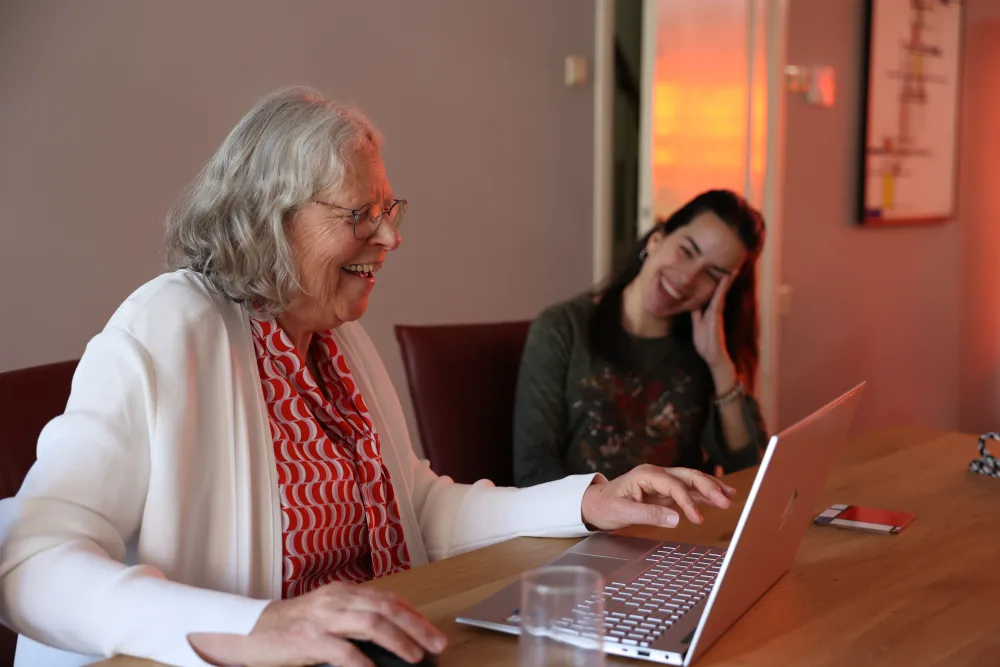 Een host en huurder kijken samen naar een advertentie op de laptop